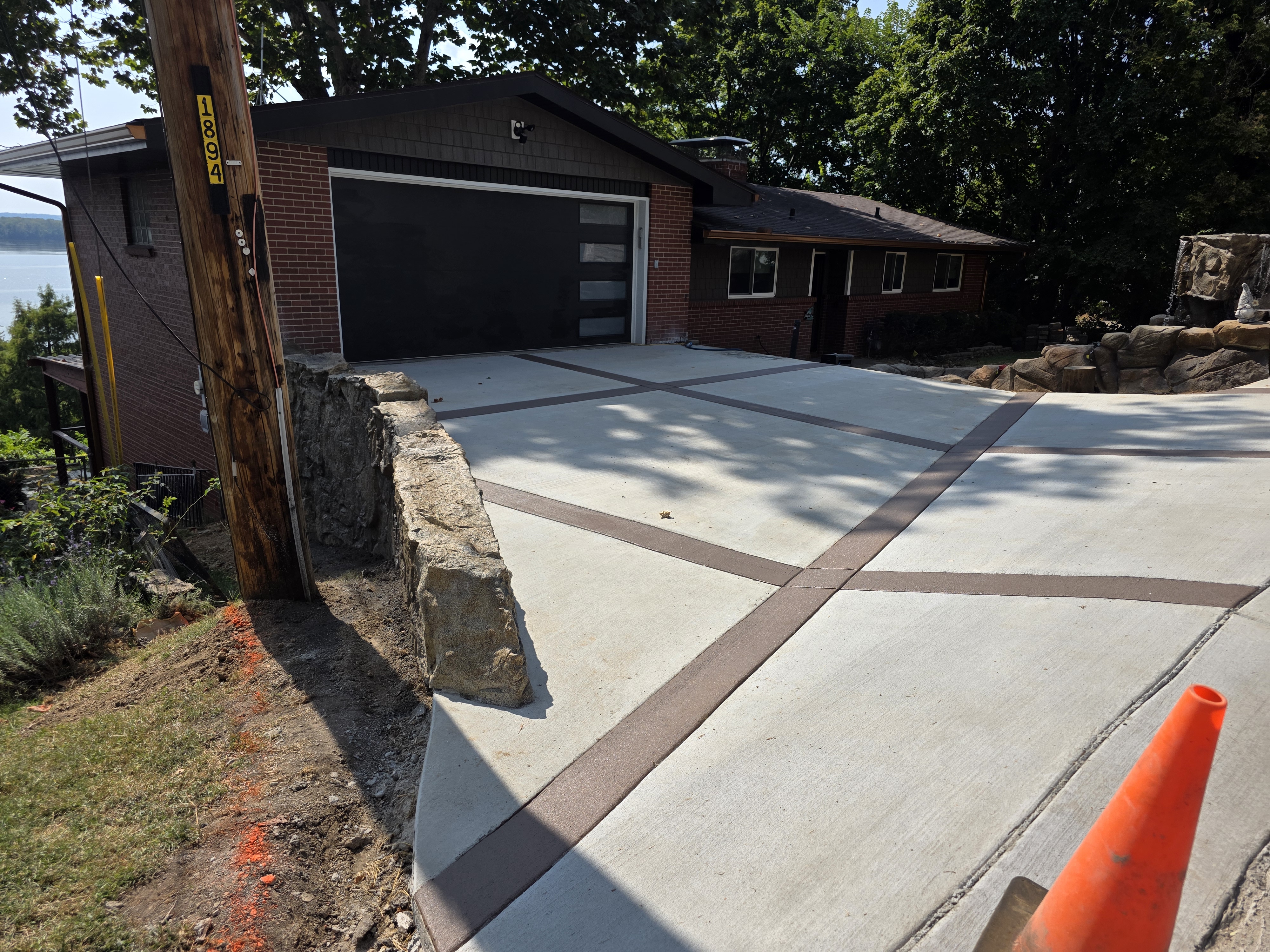 Concrete driveway with colored accent bands at a brick garage