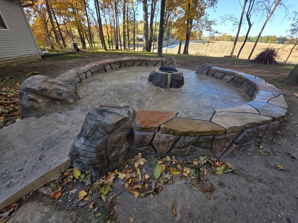 Round carved stone fire pit with a built-in seating wall