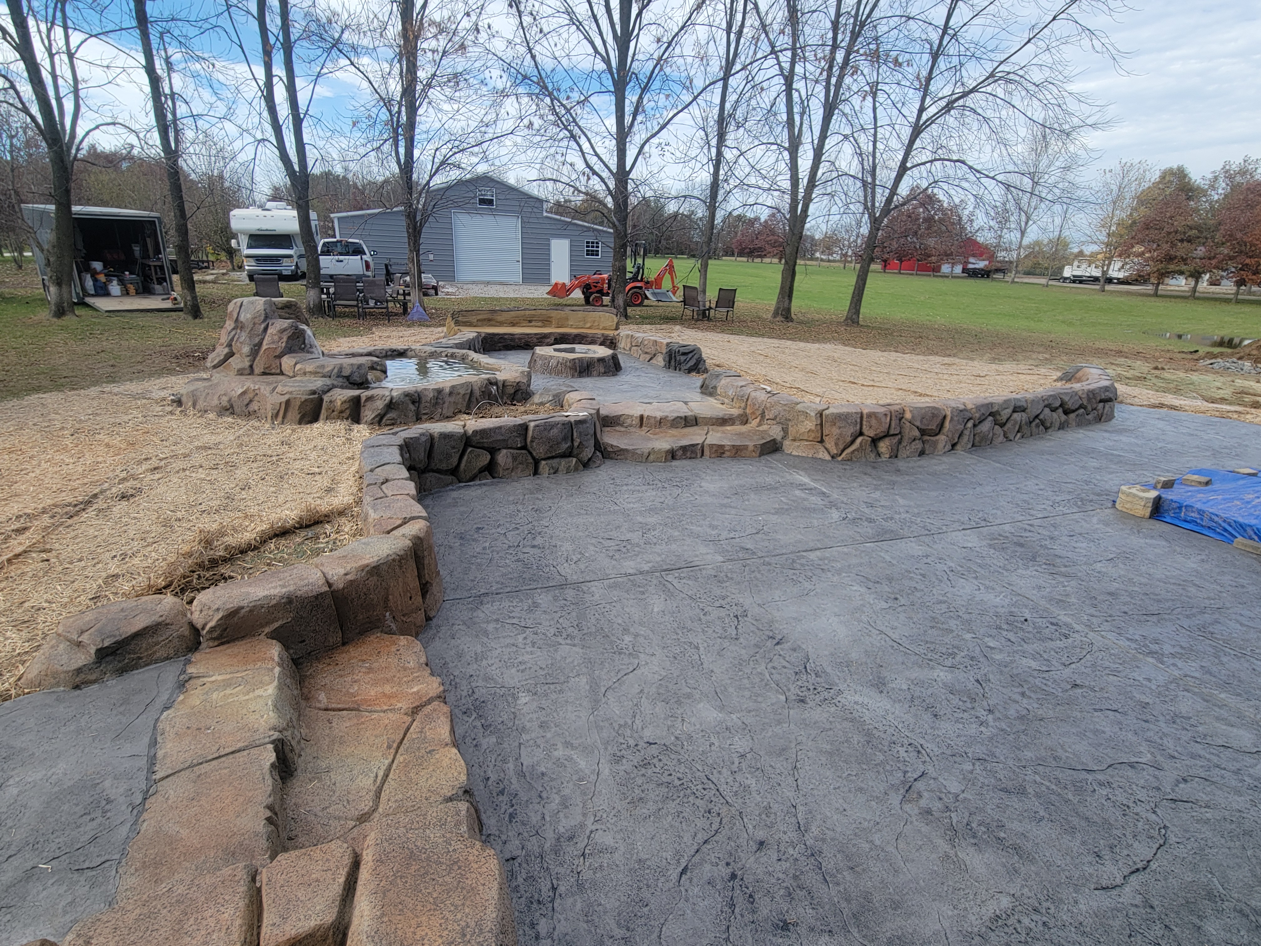 Stamped concrete patio with a carved fire pit and seating walls