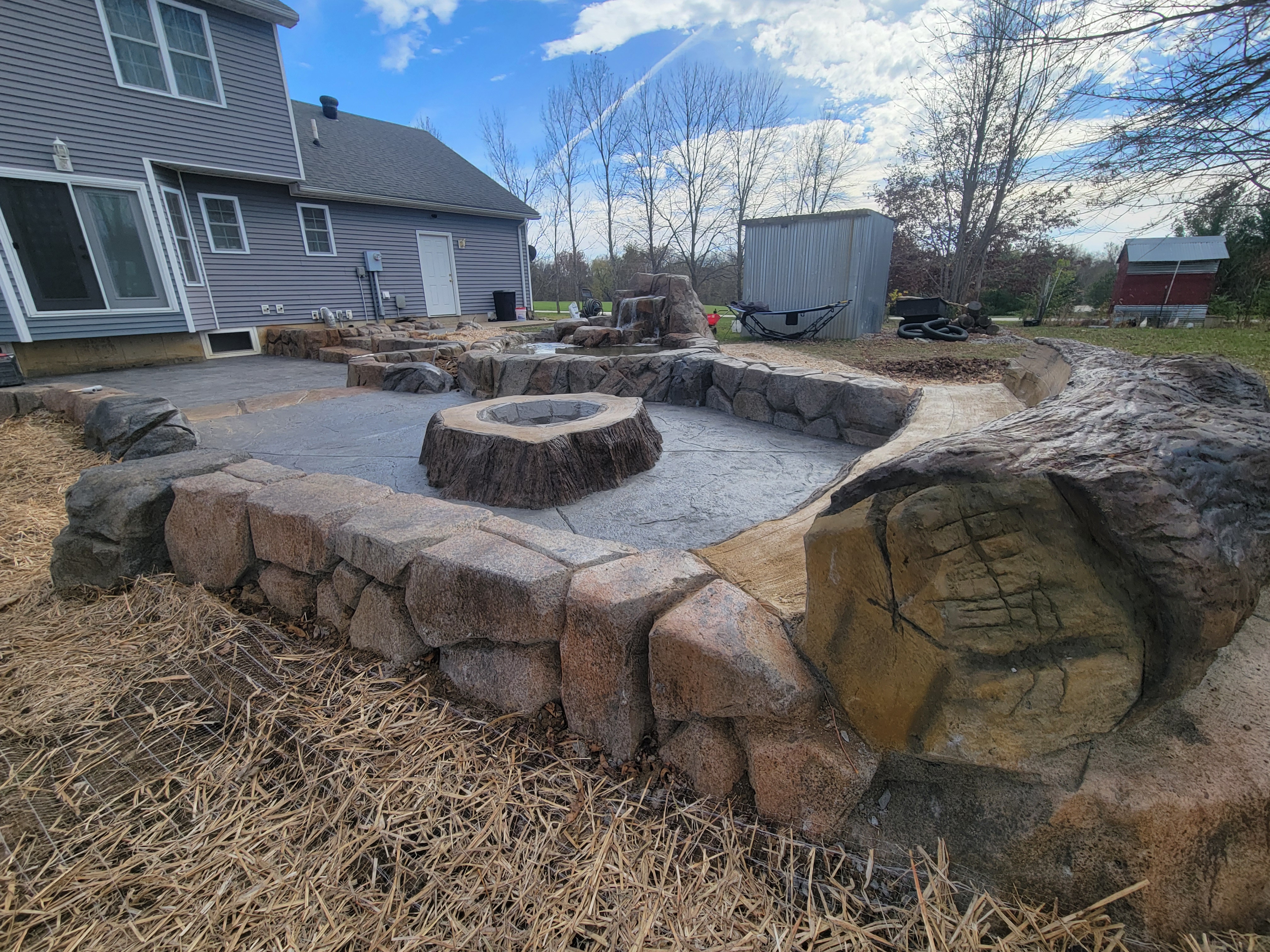 Carved boulder seating wall around a sunken fire pit