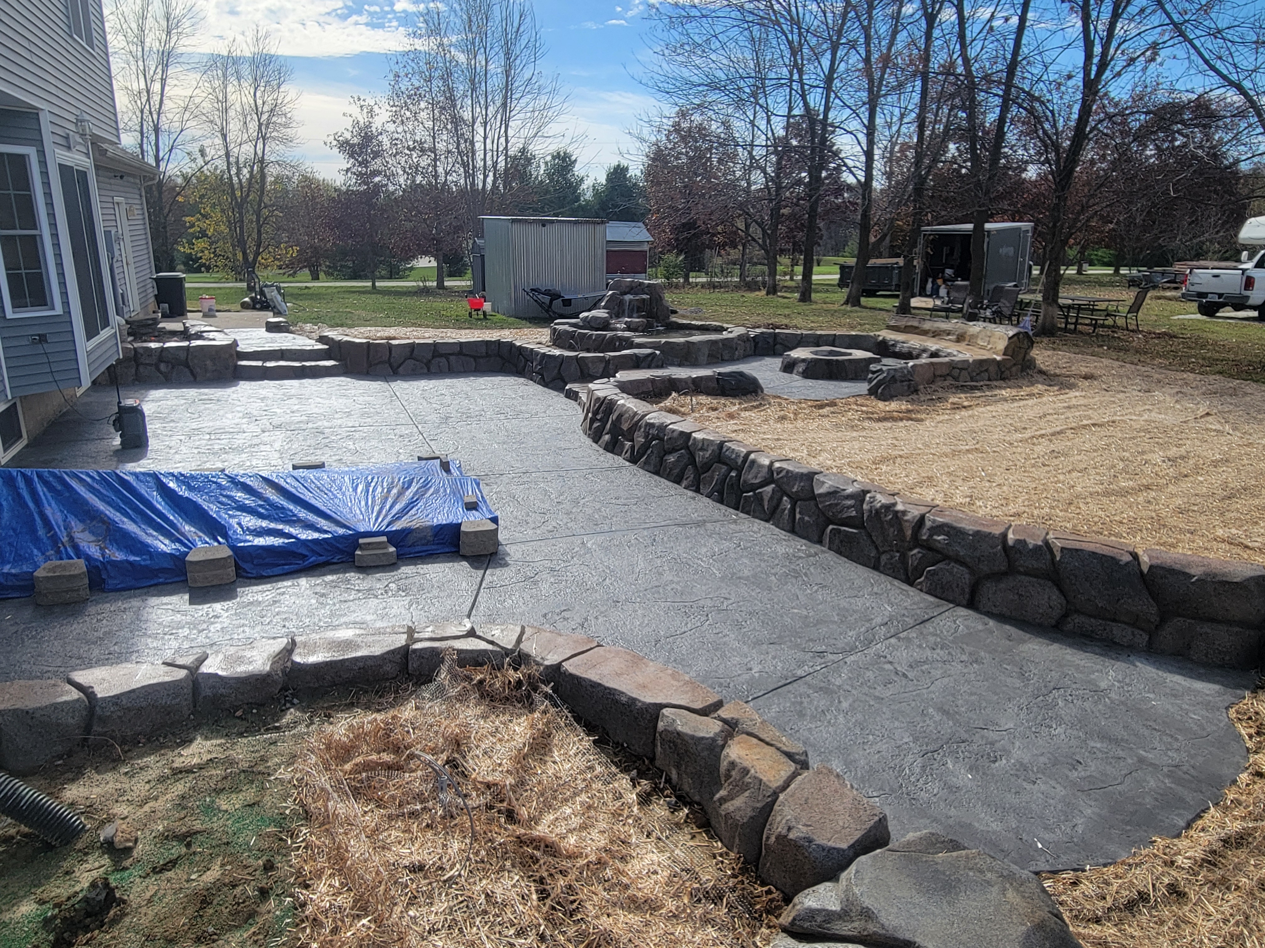 Stamped concrete patio with carved stone-look seating walls