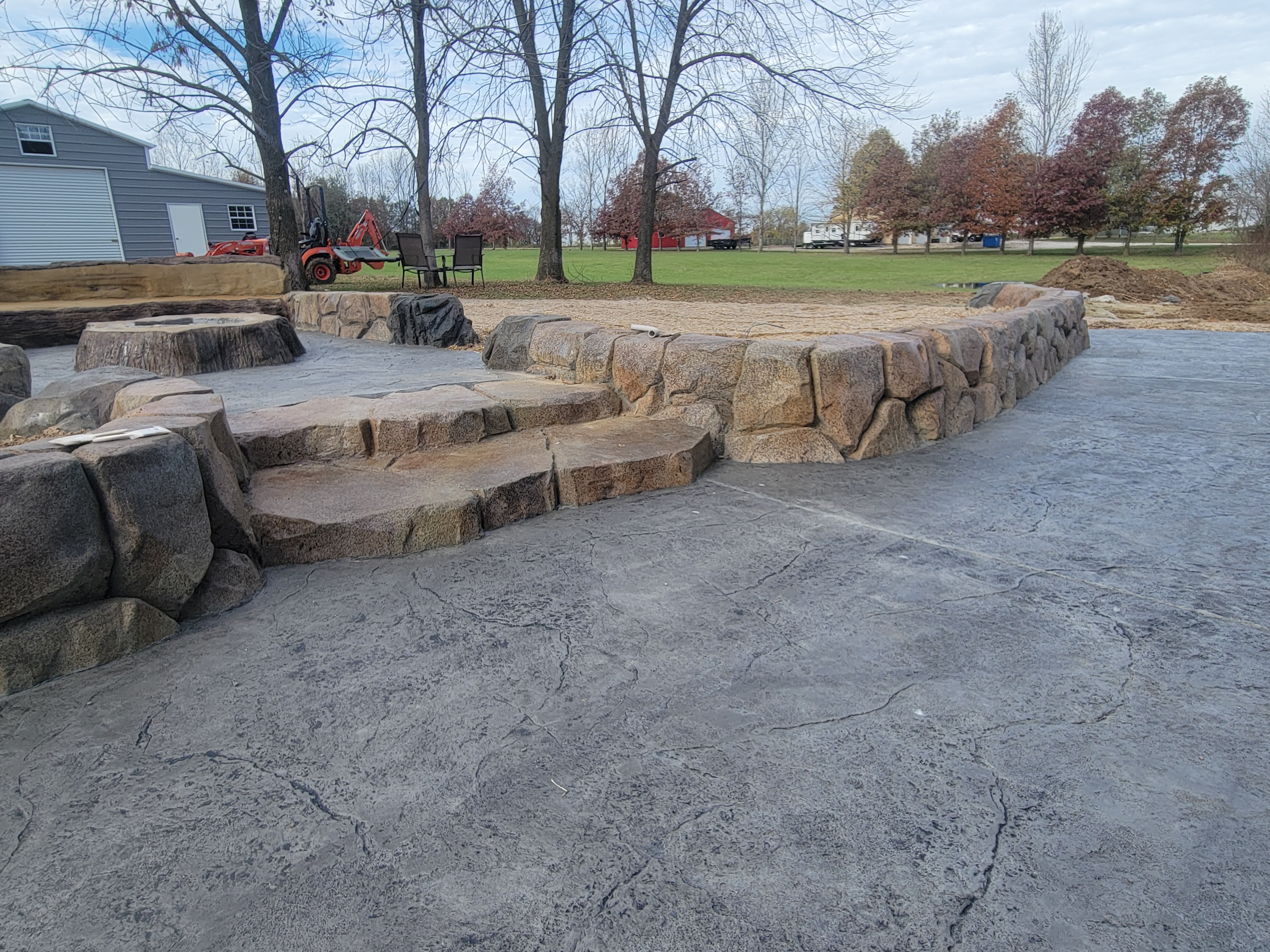 Carved boulder steps and seating wall on a stamped patio